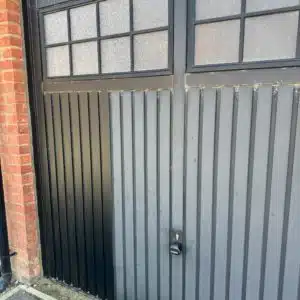 Before and after Polytrol on a black garage door 2