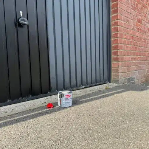 Before and after Polytrol on a black garage door