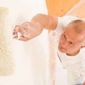 Man painting a wall with a roller