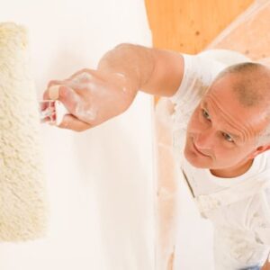 Man painting a wall with a roller