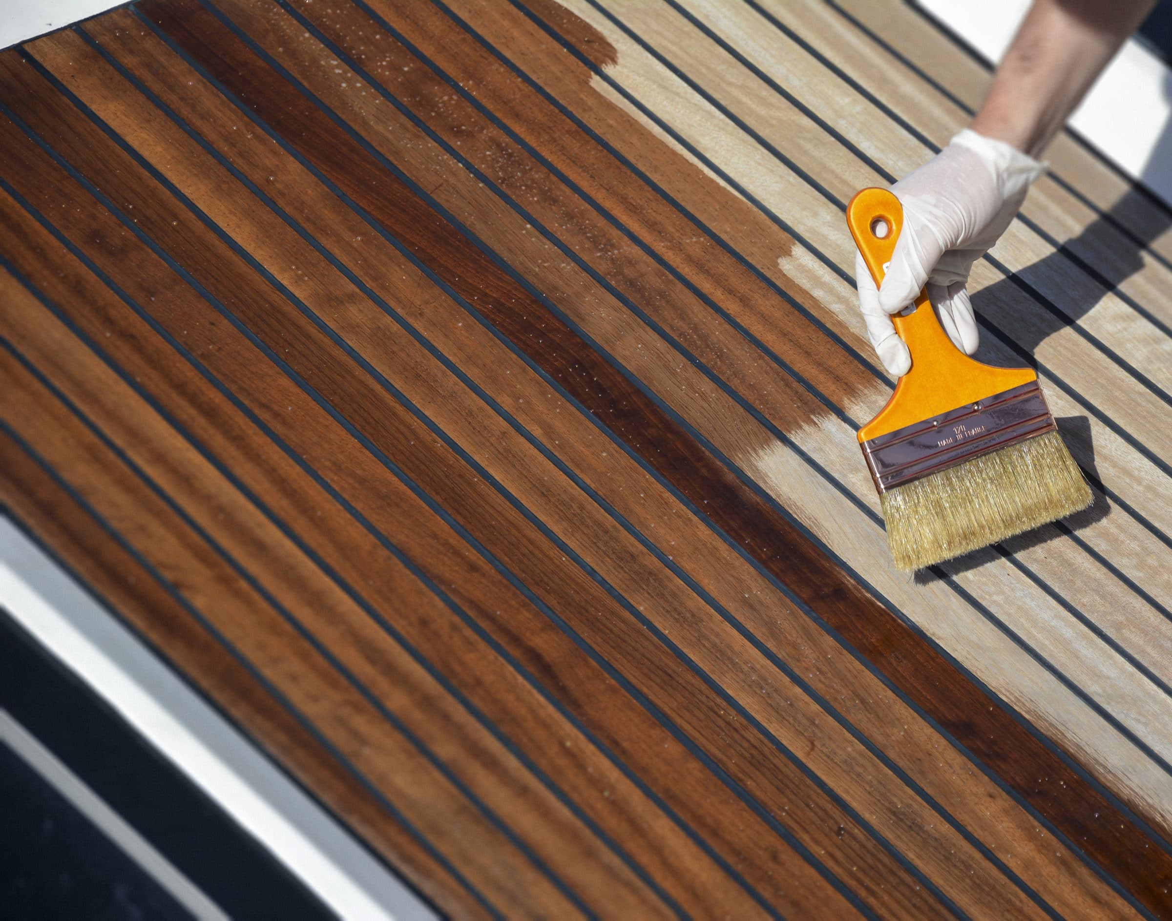 Deks Olje D1 being applied to a boat deck with a brush