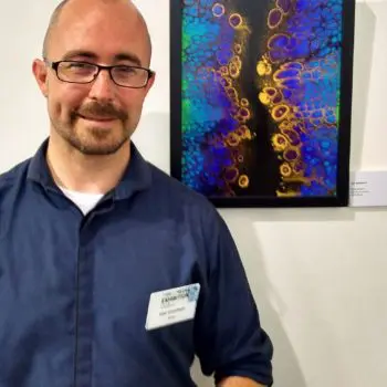 Artist Lee Goodwin next to artwork made with Floetrol