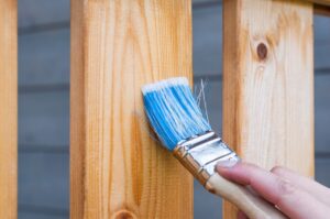 Person brushing a wooden plank