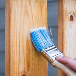 Person brushing a wooden plank
