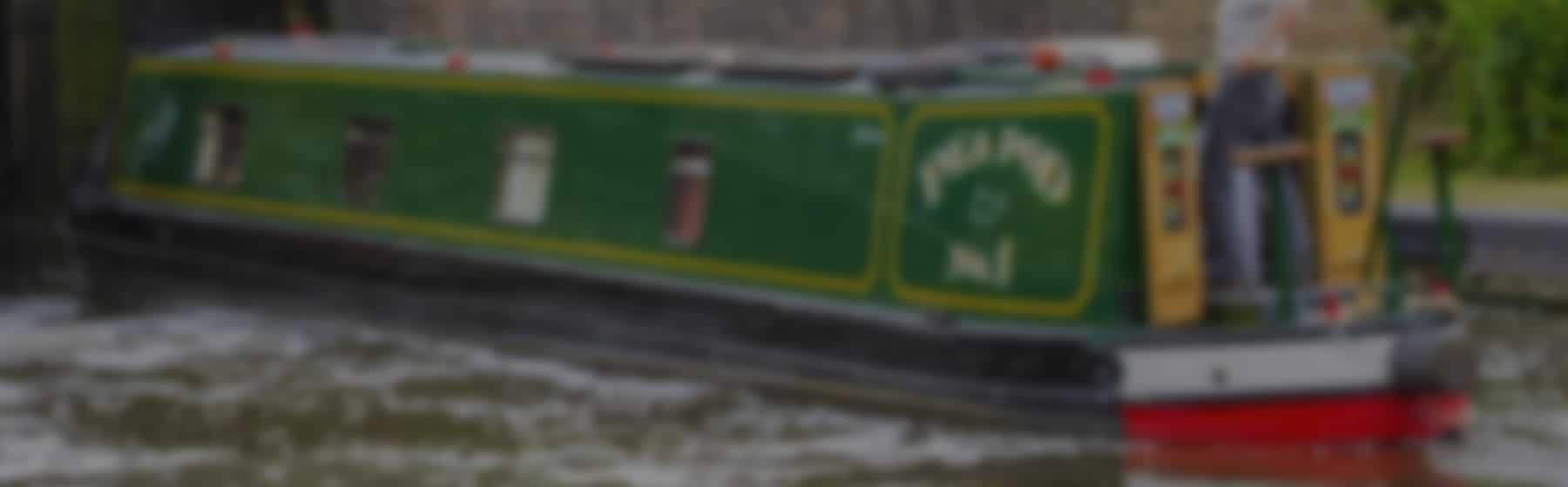 A man cruising on his green narrowboat