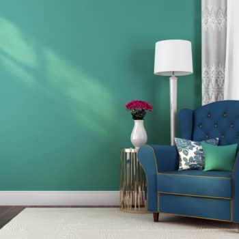 Green interior wall with blue chair and white rug