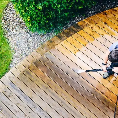 Aerial view of a man using a pressure washer on a garden deck