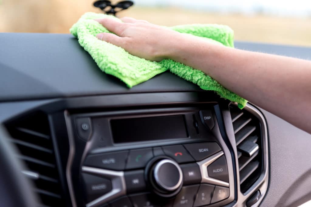 Clean a cars interior by using a microfibre cloth on a car dashboard
